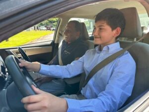 Jeune conducteur au volant, accompagné d’un adulte dans une voiture