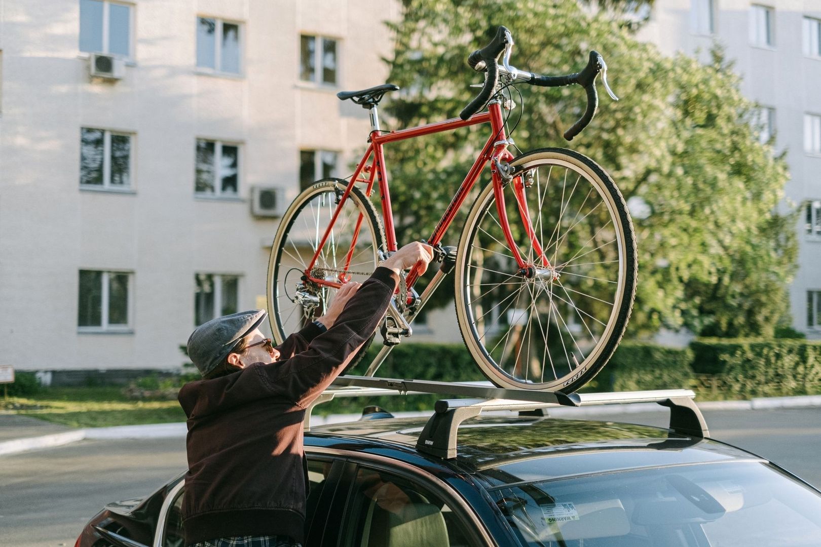 Personne fixant un vélo rouge sur le toit d